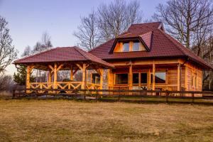 eine große Holzhütte mit einem großen Pavillon in der Unterkunft Vikendica Martinovic in Zlatibor