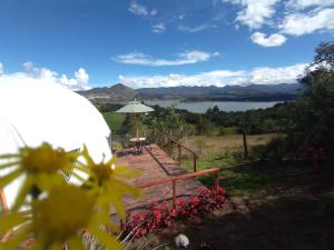 a wooden deck with a view of a lake at Glamping La Villa in Guatavita