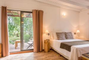 um quarto com uma cama e uma porta de vidro deslizante em La Maison Suites & Gastronomía em La Paloma