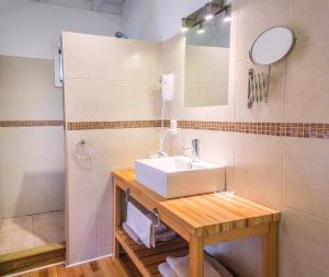 a bathroom with a sink and a mirror at La Maison Suites & Gastronomía in La Paloma