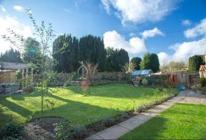 a yard with a green lawn with a tree in it at Rosedale Cottage in Rosedale Abbey