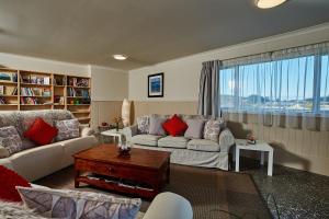 Kakatu Retreat Bed & Breakfast في كايكورا: غرفة معيشة مع أريكة وطاولة