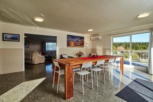 a dining room with a wooden table and chairs at Kakatu Retreat Bed & Breakfast in Kaikoura