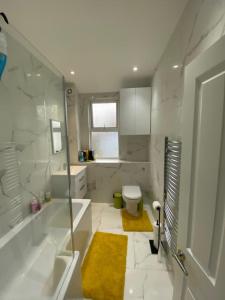 a white bathroom with a tub and a toilet at Breeze on Southend in Essex in Southend-on-Sea