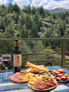 a table with a bottle of wine and plates of food at Casa en La Cumbrecita in La Cumbrecita