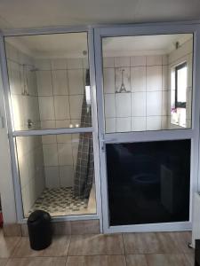 puerta corredera de cristal con baño con ducha en ILITHA PARK en Ciudad del Cabo