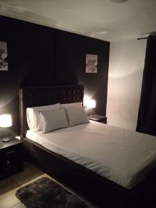ein Schlafzimmer mit einem großen weißen Bett mit zwei Lampen in der Unterkunft ILITHA PARK in Kapstadt