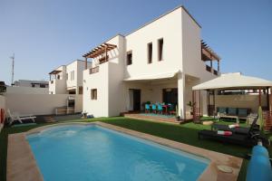 Villa con piscina frente a una casa en Villa Las Caletas del Mar - Heated Pool en Costa Teguise