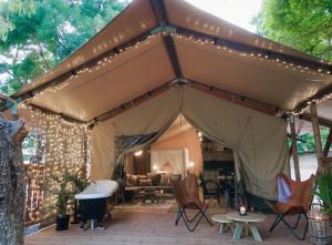 a tent with lights and chairs in a yard at Castlemaine Gardens Luxury Safari Tents in Castlemaine