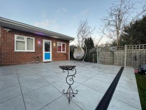 a patio with a grill in front of a house at Modern Garden House in Harrow