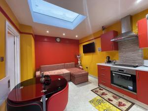 - une cuisine avec un canapé et une table dans une chambre dans l'établissement Modern Garden House, à Harrow