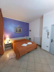 een slaapkamer met een oranje bed en een blauwe muur bij Hotel Arcella in Padua