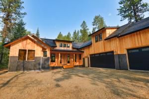 a large wooden house with two garage doors at White Bark Lodge by Casago McCall - Donerightmanagement in McCall