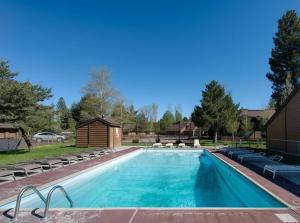 a large swimming pool with chairs and a house at Laid Back Lounge by Casago McCall - Donerightmanagement in McCall