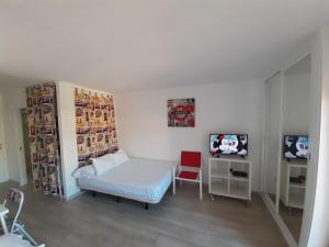 ベナルマデナにあるJupiter Apartments Sea Viewのベッド1台とテレビが備わる小さな客室です。