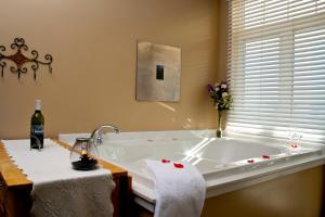 a bathroom with a bath tub with a bottle of wine at Weathervane Inn in Montague