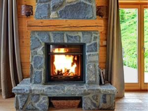 a fireplace in a room with a stone wall at Modern Chalet with bubble bath in Les Collons in Les Collons