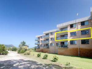 un immeuble d'appartements avec une pelouse devant lui dans l'établissement Intrepid 10 water views over Shoal Bay Beach, à Shoal Bay