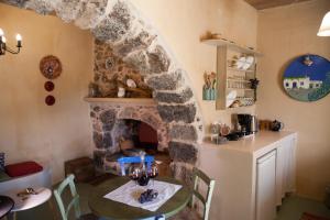 a kitchen with a stone fireplace and a table in a room at Sitanos Anna House in Sítanos
