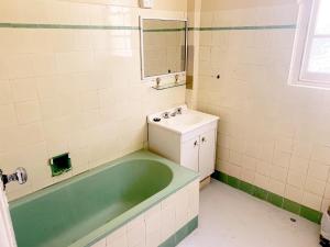 a bath tub sitting next to a sink in a bathroom at Port Macquarie Hotel in Port Macquarie