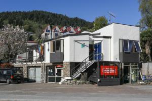 a large white building on the side of a street at Aspen Lodge Backpackers in Queenstown