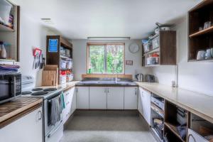 uma cozinha com armários brancos, um lavatório e uma janela em Aspen Lodge Backpackers em Queenstown