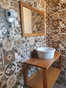 a bathroom with a mirror and a sink on a table at Pousada Mar e Moto in Guaratuba
