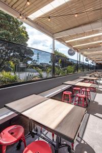 a row of tables and red stools in a restaurant at Five Island Hotel in Cringila