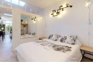 a white bedroom with a bed and a mirror at BANDOL Magnifique appartement en RDC cour sans vis à vis 5mn plage in Bandol