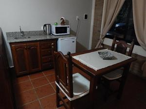 a small kitchen with a table and a microwave at Romance de Luna.- Monoambientes.- in San José