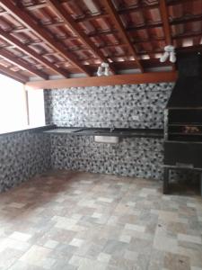 an empty room with a stove and a tile floor at Casa Ubatuba Perequê Açu in Ubatuba