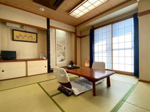 ein Zimmer mit einem Tisch und Stühlen in einem Zimmer in der Unterkunft Toyofuku in Kōbe