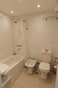 uma casa de banho com um WC, uma banheira e um lavatório. em Departamento Playa 3 em Mar del Plata