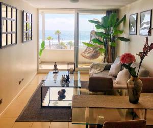 a living room with a couch and a glass table at Aqua La Serena in La Serena
