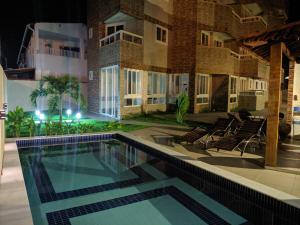 a swimming pool in front of a building at night at MAKAIBA RESIDENCE 302 - Coração de Porto e Piscinas Naturais in Porto De Galinhas