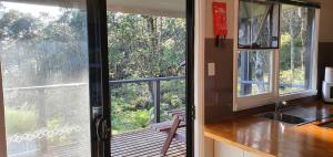 a kitchen with a sliding glass door to a balcony at Cradle Alpine Retreat in Moina