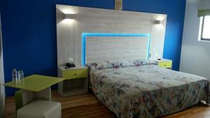 a bedroom with a bed and a blue wall at Hotel Gilbert in Mexico City +3 photos