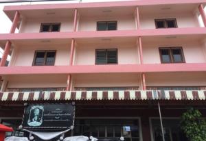 a pink building with a sign in front of it at Lukmuang 2 Hotel in Phangnga
