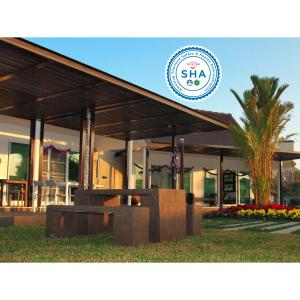 a building with a palm tree in front of it at Chiangrai Green Park Resort in Chiang Rai