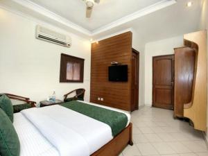 a bedroom with a bed and a television in it at Hotel Paradise Chandigarh in Chandīgarh