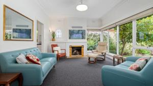 sala de estar con muebles azules y chimenea en Lake side, opposite botanical gardens! Views! en Wendouree