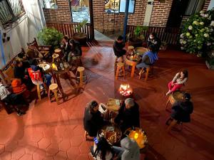 um grupo de pessoas sentadas em mesas em um pátio em Hostal Traveland em Pichilemu