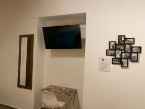 a room with a tv on a wall with pictures at Casa Universidad in Guanajuato +69 photos