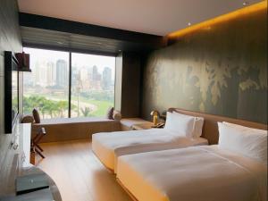 a hotel room with two beds and a large window at The Macau Roosevelt Hotel in Macau