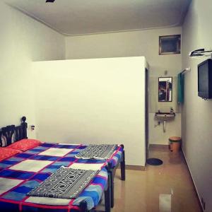 una camera con due letti e una tv di Chandraprabha Nyahari Niwas a Malwan
