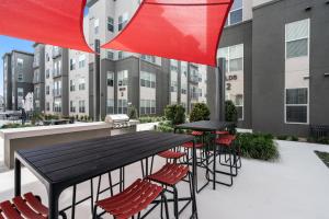 a patio with black tables and chairs and buildings at Kasa Highland Park Dallas in Dallas