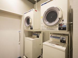 a laundry room with two machines and a washer and dryer at Tamayura Hotel Asakusa in Tokyo