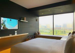 a bedroom with a bed and a flat screen tv at The Macau Roosevelt Hotel in Macau
