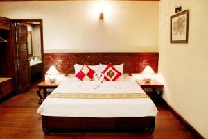 1 dormitorio con 1 cama grande con almohadas rojas en Blue Shell Resort, en Mui Ne