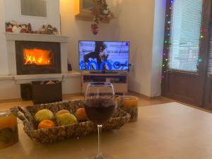 パンポロボにあるRaikov Ski Lodge private apartmentsのワイン1杯(テーブルの上に置いて、フルーツバスケット付)
